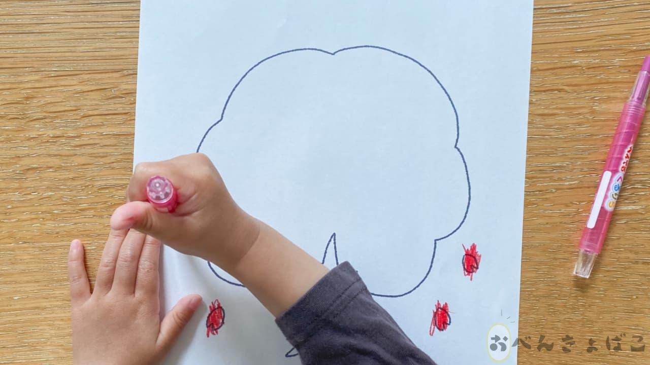 無料知育プリントの塗り絵をクレヨンで塗る子どもの手