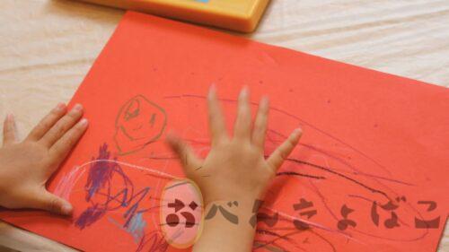 画用紙に好きなことを描く子どもの手